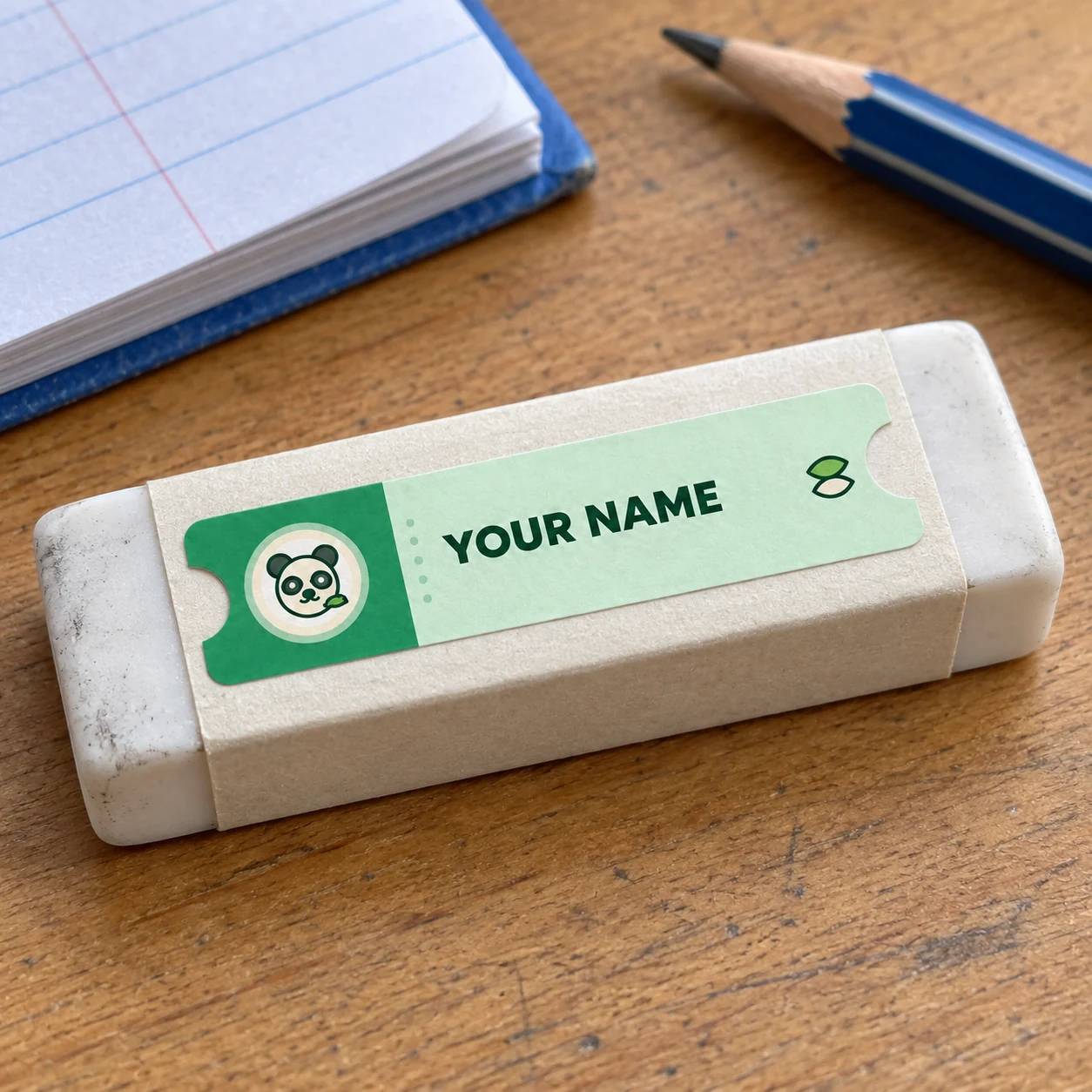 Green panda name tag sticker reading YOUR NAME on a school eraser sleeve