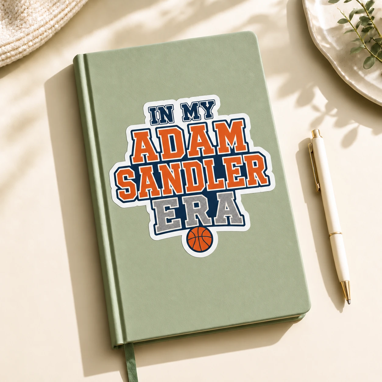 In My Adam Sandler Era Sticker, Varsity Basketball design shown on a notebook