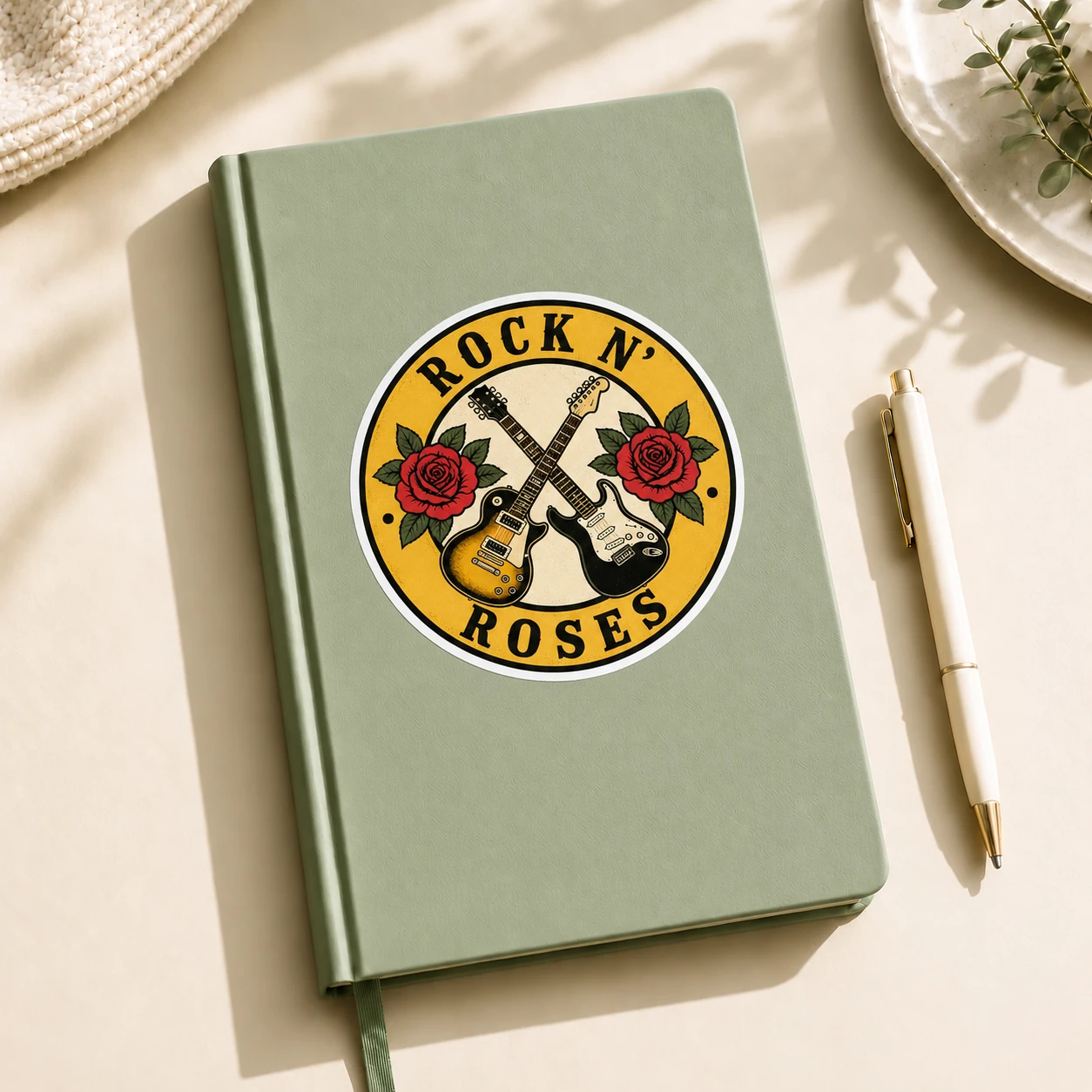 Rock ’n’ Roses Sticker, Crossed Guitars design shown on a notebook