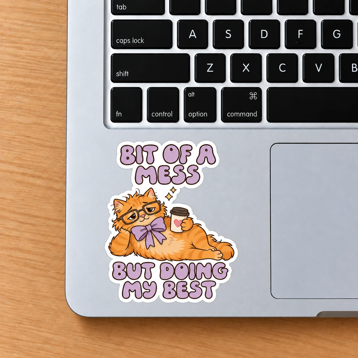 Bit of a Mess Sticker, Coffee Cat design shown on a laptop palm rest