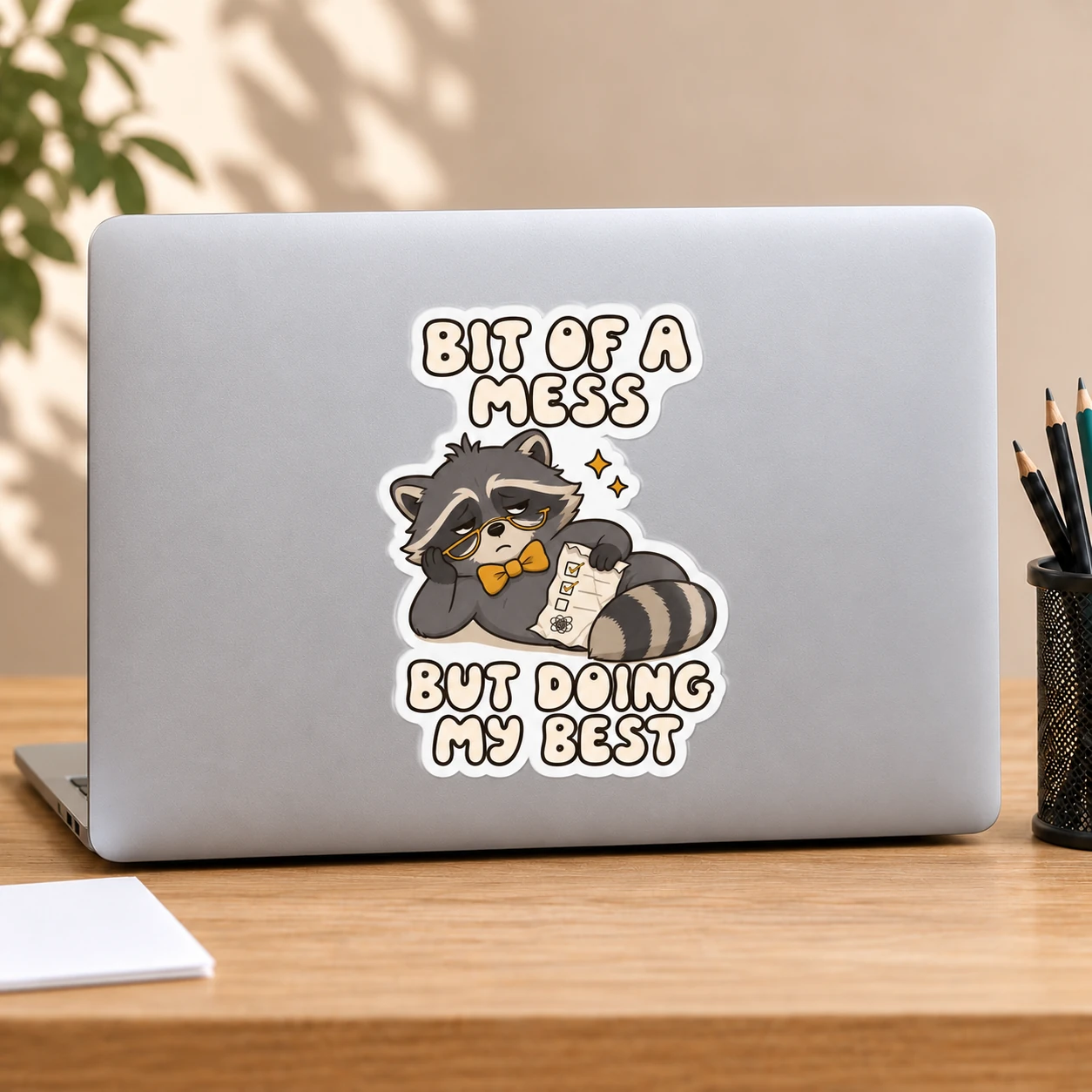 Bit of a Mess Sticker, Checklist Raccoon design shown on a laptop lid
